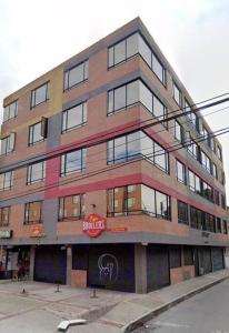a tall building with a sign on the side of it at Moderno apartamento cerca al aeropuerto in Bogotá