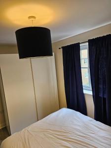 een slaapkamer met een bed, een lamp en een raam bij 3/4 bedrooms, Free Parking, Wifi, Home away from home feel in Purfleet