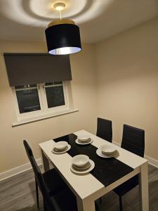 een eetkamer met een tafel met stoelen en een licht bij 3/4 bedrooms, Free Parking, Wifi, Home away from home feel in Purfleet