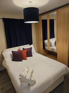 een slaapkamer met een groot bed en handdoeken bij 3/4 bedrooms, Free Parking, Wifi, Home away from home feel in Purfleet