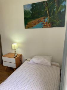 a bedroom with a bed and a painting on the wall at Disfruta Colombia!. in Bucaramanga