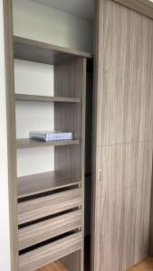 a closet with wooden shelves in a room at Disfruta Colombia!. in Bucaramanga