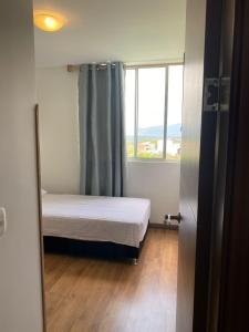 a small bedroom with a bed and a window at Disfruta Colombia!. in Bucaramanga