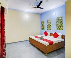 - une chambre avec un lit et des oreillers rouges dans l'établissement OYO Flagship 81042 Hotel Royal Inn, à Manesar