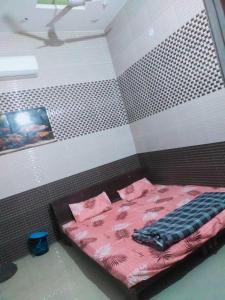 um quarto com uma cama com lençóis cor-de-rosa e almofadas cor-de-rosa em OYO 81088 Hr Guest House em Kurukshetra