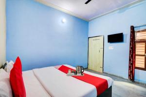 Cette chambre dispose d'un lit aux murs bleus et d'une télévision. dans l'établissement OYO Flagship 81042 Hotel Royal Inn, à Manesar