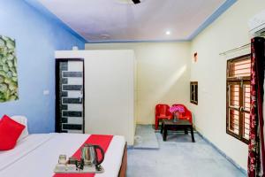 1 dormitorio con 1 cama y 1 silla roja en OYO Flagship 81042 Hotel Royal Inn en Manesar