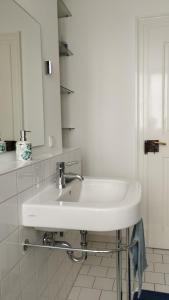 a white bathroom with a sink and a mirror at Stadthaus Zimmer 6 neben dem REM-Museum in Mannheim Mitte in Mannheim