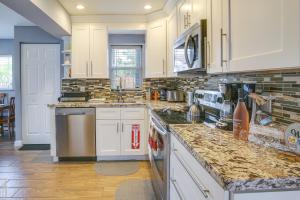 a kitchen with white cabinets and marble counter tops at Private Pool and Patio Fort Lauderdale Home! in Fort Lauderdale