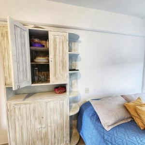 1 dormitorio con 1 cama y armario de madera en DelaIglesia en San Salvador de Jujuy