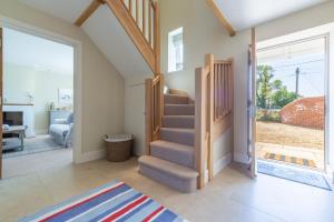 a living room with a staircase and sliding glass doors at Flint House W in Wighton