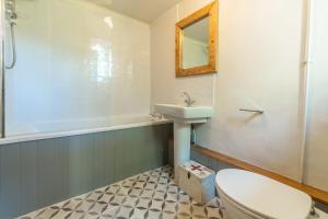 a bathroom with a toilet and a sink and a tub at Willow Cottage in North Creake