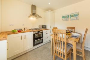 a kitchen with a table and a stove top oven at Seagrace in Heacham +11 photos
