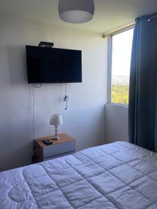 Schlafzimmer mit einem Bett und einem Flachbild-TV in der Unterkunft HABITACION DOBLE con baño compartido en apartamento compartido in Bucaramanga