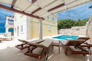 a patio with two chairs and a swimming pool at Holiday house with a swimming pool Prizba, Korcula - 199 in Prizba