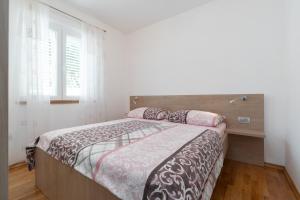 ein Schlafzimmer mit einem Bett und einem Fenster in der Unterkunft Holiday house with a swimming pool Prizba, Korcula - 199 in Prizba + 29 Fotos