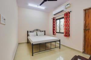a room with a bed and a window in a room at OYO Flagship 81094 Bay Breeze Hotel in Baga
