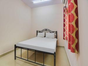 a small bedroom with a bed in a room at OYO Flagship 81094 Bay Breeze Hotel in Baga