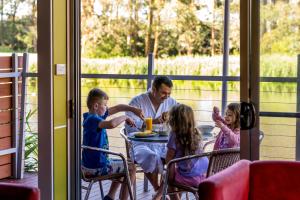 Tall Timbers Tasmania في سميثتون: رجل يجلس على طاولة مع ثلاثة أطفال يجلس على طاولة
