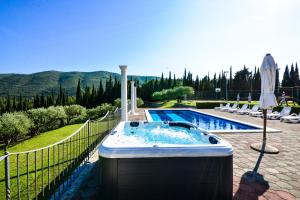 bañera de hidromasaje en un patio junto a la piscina en Luxury villa with a swimming pool Zastolje, Dubrovnik - 14922, en Gruda