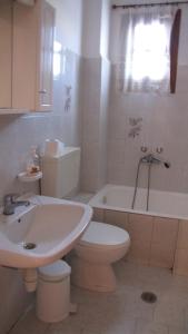 a bathroom with a toilet and a sink and a tub at Rafaela House in Milína