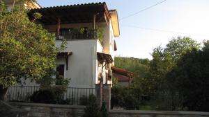 a white house with a fence and trees at Rafaela House in Milina