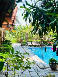 a swimming pool in the middle of a garden at Tam Coc Summer Bungalow in Ninh Binh