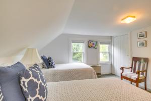 a bedroom with two beds and a chair and two windows at Rockland Home with Deck 5 Mins to Historic Downtown! in Rockland