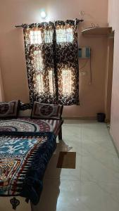 1 dormitorio con cama y ventana con luces en OYO 81144 Royal Guest House, en Jīnd