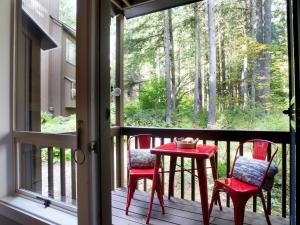 - deux chaises et une table sur une terrasse couverte avec moustiquaire et fenêtre dans l'établissement Mt Baker Den, Sleeps 4, à Glacier