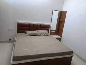 1 cama en un dormitorio con espejo en la pared en OYO HOME RKR.inn, en Dabok