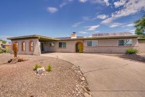 a house with a solar roof on a driveway at Vibrant, Colorful Tucson Abode w/ Pool & Hot Tub in Tucson