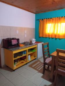 a kitchen with a counter and a sink and a table at El refugio Anillaco in Anillaco