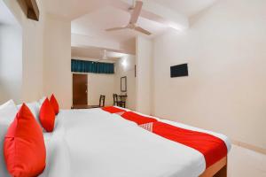 a bedroom with a large white bed with red pillows at Casa Paradiso in Panaji