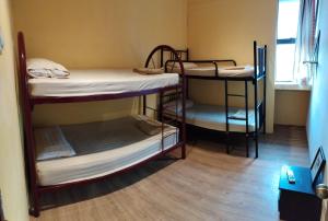 a room with three bunk beds and a window at Ringo's Foyer in Melaka