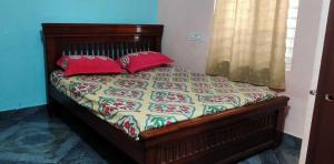 a bed with red pillows in a bedroom at OYO HOME 81185 Srinivas Service Home in Rājahmundry