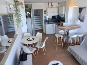 a small kitchen and living room with a table and chairs at L'Océan&Dunes vue à 180° en bord de plage in Lacanau-Océan