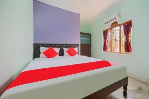 a bedroom with a large bed with red pillows at OYO Flagship 81152 Hotel Raz Stays in Bhubaneshwar
