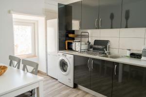 a kitchen with a sink and a washing machine at Casa Sabino in Almádena
