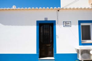 un edificio azul y blanco con puerta en Casa Sabino, en Almádena