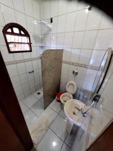 ein Bad mit einem WC und einem Waschbecken in der Unterkunft Bourguignon in Piúma