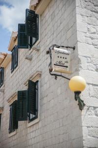 a sign on the side of a building with green shutters at Apartments by the sea Kastel Novi, Kastela - 21210 in Kaštela