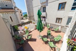 a patio with a green umbrella and chairs and tables at Apartments by the sea Kastel Novi, Kastela - 21210 in Kaštela