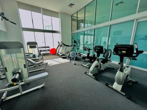 a gym with cardio equipment in a building with windows at Cozy Chic Haven: Modern Comfort in Gold Coast