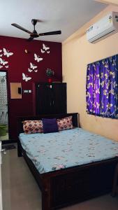 a bedroom with a bed with butterflies on the wall at OYO 81239 Shri Vinayaka Inn Rooms in Tiruchchirāppalli