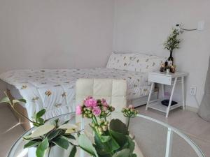 een woonkamer met een bed en een tafel met bloemen bij 10 mins from Nowon Station! Happy House in Seoul