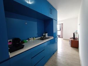 een blauwe keuken met een wastafel en blauwe kasten bij Halo Sunday Empire City by Kenangan Home 4 Paxs Room in Petaling Jaya