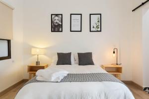 1 dormitorio con 1 cama blanca y 3 cuadros en la pared en Great location. Renovated apartament in Roma Norte en Ciudad de México