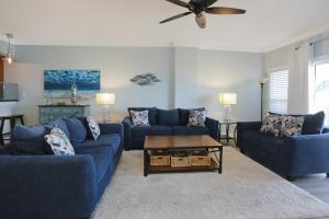 salon z niebieskimi kanapami i stołem w obiekcie Paradise Shores 302 Serenity Shores by Pristine Properties Vacation Rentals w mieście Mexico Beach