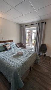 a bedroom with a bed and a large window at Motel Gentilhommière in Saint-Siméon